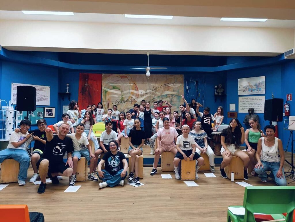 foto di cinquanta studenti dell'istituto comprensivo Pertini che suonano dei tamburi